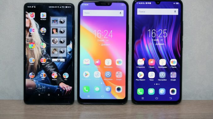 Billige smartphones i forskellige farver Tre moderne smartphones i forskellige farver