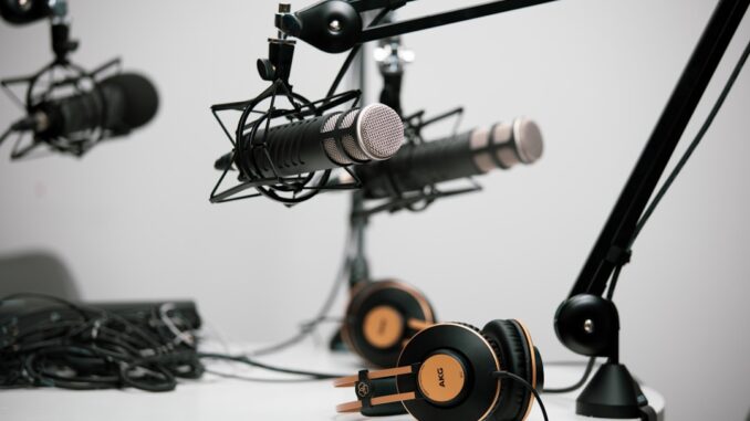 Podcastmikrofoner på mikrofonarme ved et bord